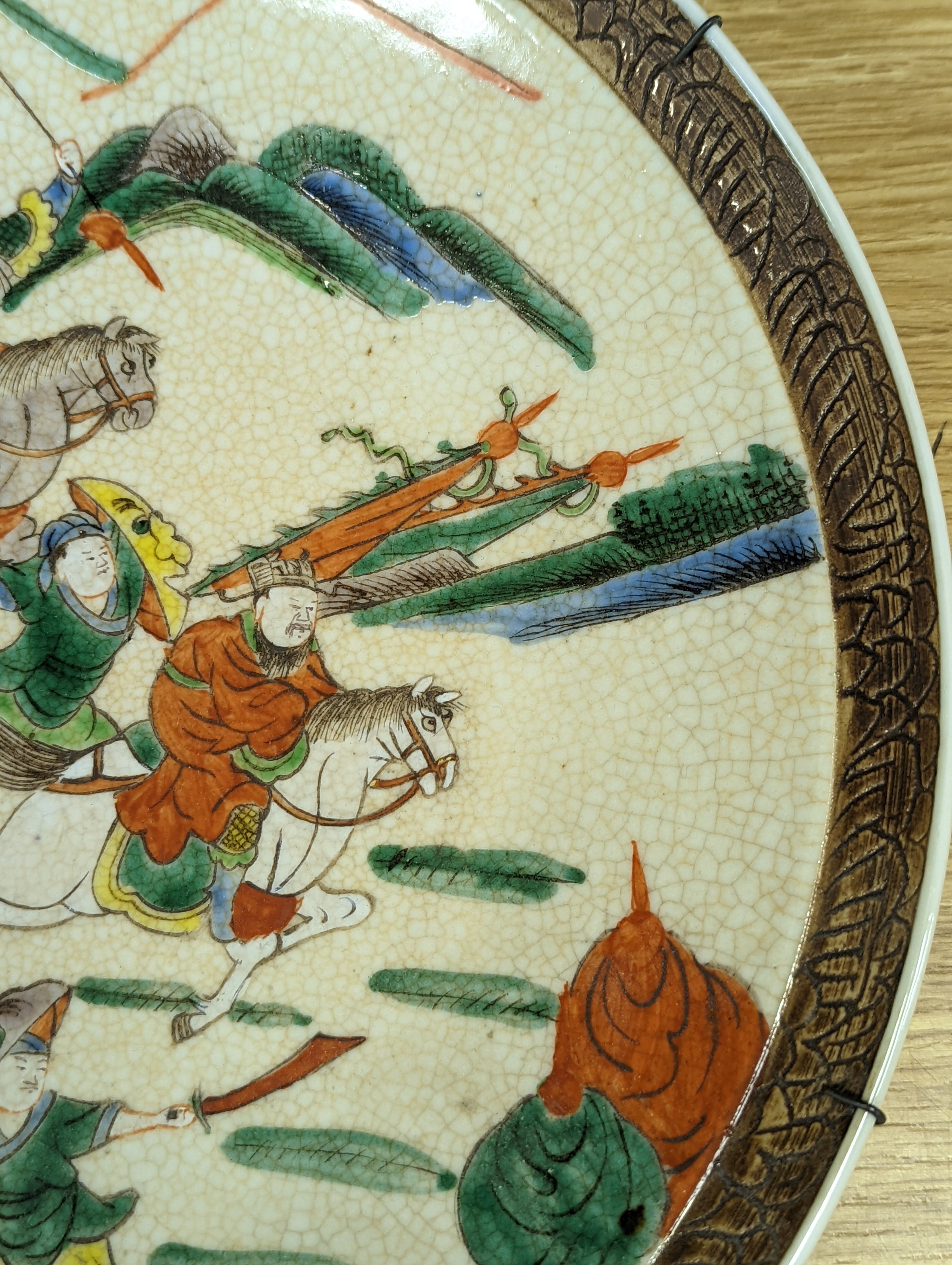 A Chinese crackle glaze dish, early 20th century, depicting a battle scene 33cm